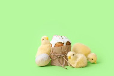 Paskalya pastası, boyalı yumurta ve yeşil arka planda civcivler, yakın plan.