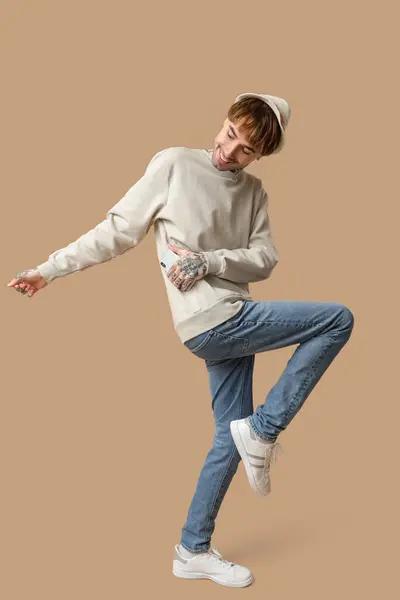 Młody Wytatuowany Mężczyzna Tańczący Beżowym Tle — Zdjęcie stockowe