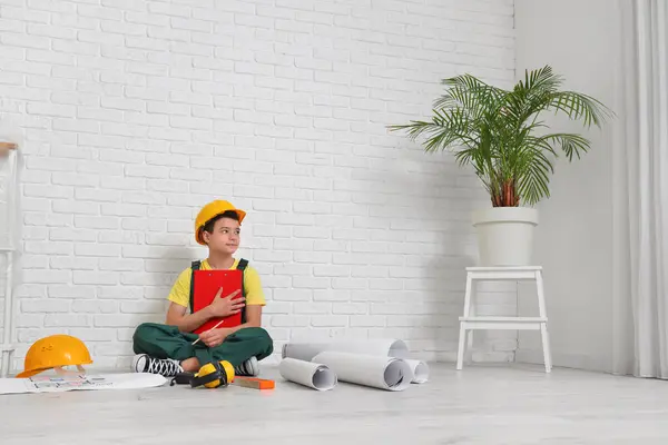 Little architect with clipboard sitting in room