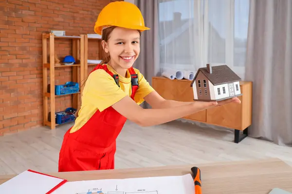 Little architect with house model in room