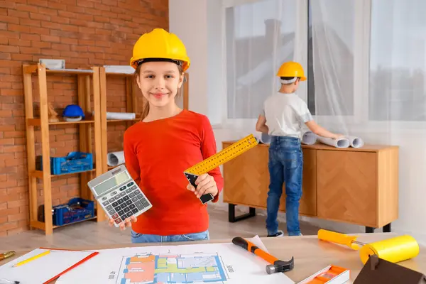 Little architect with calculator and ruler in room