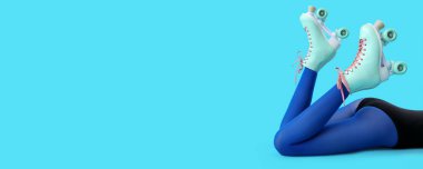 Mavi arka planda paten giyen ve metin için yeri olan kadınların bacakları