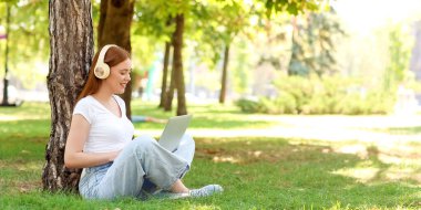 Parkta müzik dinleyen genç bir kadın