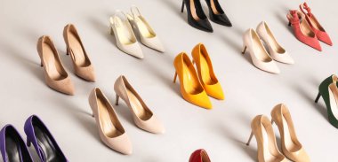 Arka planda çok farklı yüksek topuklu ayakkabılar var.