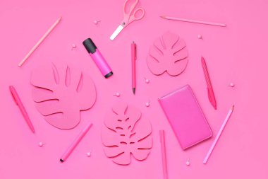 Pembe arka planda farklı kırtasiye malzemesi ve kağıt palmiye yaprakları olan kompozisyon