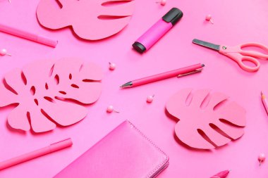 Pembe arka planda farklı kırtasiye malzemesi ve kağıt palmiye yaprakları olan kompozisyon