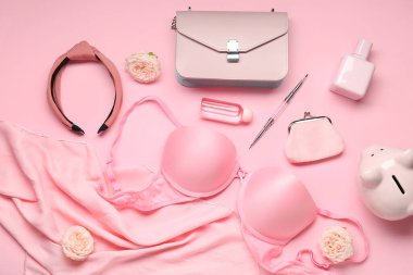 Pembe arka planda kadın aksesuarları, kozmetik ürünleri ve çiçeklerle kompozisyon