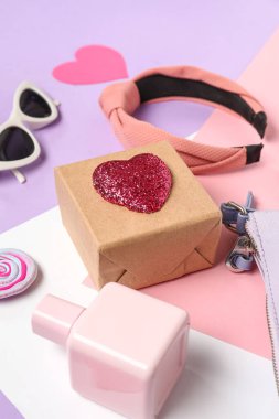 Hediye kutusu, parfüm şişesi ve kadın aksesuarları.