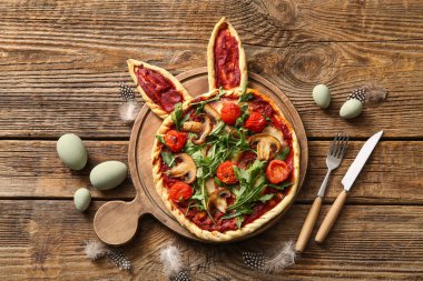 Ahşap arka planda lezzetli pizza ve yumurta kompozisyonu. Paskalya kutlaması