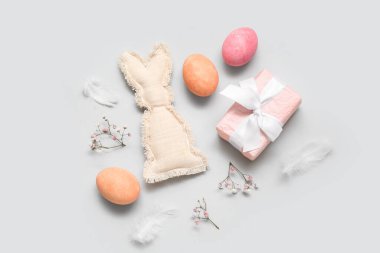 Boyalı Paskalya yumurtaları, hediye kutusu ve beyaz arka planda oyuncak tavşan.