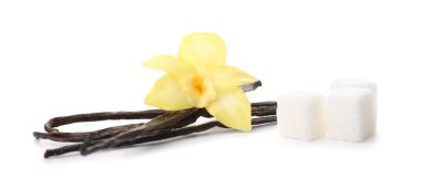 Beyaz arka planda vanilya çubukları, şeker ve çiçek