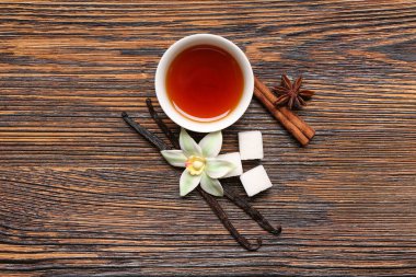 Tahta zemin üzerinde vanilya özlü, çubuklu, çiçekli ve baharatlı kompozisyon