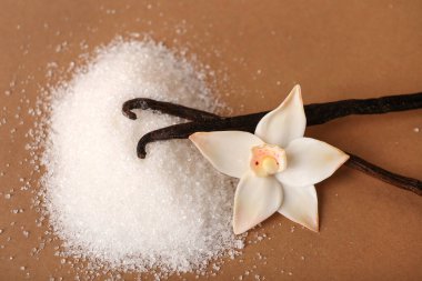 Renkli arkaplanda vanilya şekeri, çubuk ve çiçek yığını