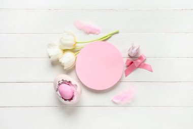 Laleli boş kart, paskalya yumurtası ve beyaz ahşap arka planda dekor.
