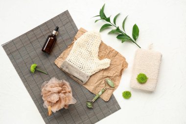 Açık arkaplanda spa aksesuarları ve çiçekleri olan kompozisyon