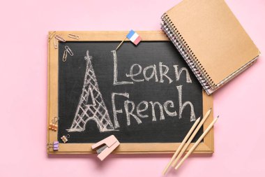 Tebeşir tahtası üzerinde LEARN FRENCH ve pembe arkaplan kırtasiyesi