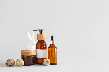 Kozmetik ürünler seti, Paskalya yumurtası ve seramik arka planda tavşan.