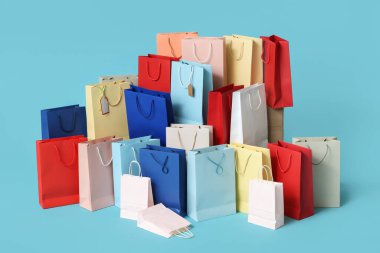 Mavi arka planda bir sürü alışveriş çantası