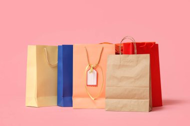 Pembe arka planda bir sürü alışveriş çantası