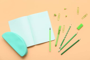 Bej arkaplanlı kalemli defter. Üst görünüm