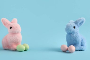 Güzel Paskalya tavşanları ve yumurtalar mavi arka planda