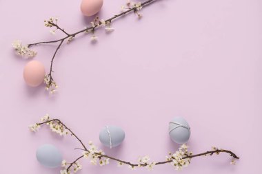 Paskalya yumurtaları ve leylak arka planda çiçek açan dallar. Üst görünüm