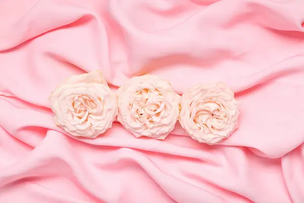 粉色面料背景上美丽的花朵 — 图库照片