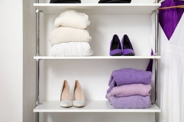 Modern kadınların giysilerinde kazaklar ve topuklu ayakkabılar.