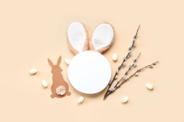 Tavşan kulaklı boş kart, Paskalya yumurtası ve bej arka planda söğüt dalları.