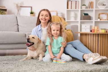 Annesi ve Labrador köpeği olan küçük bir kız.