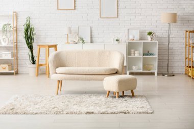 Beyaz kanepe ve divanı olan modern bir oturma odası.