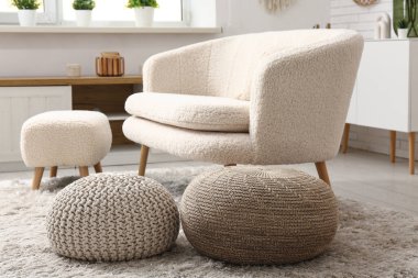 Kanepesi ve pufları olan modern oturma odasının içinde.