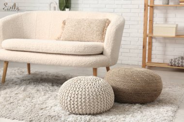 Kanepesi ve pufları olan modern oturma odasının içinde.