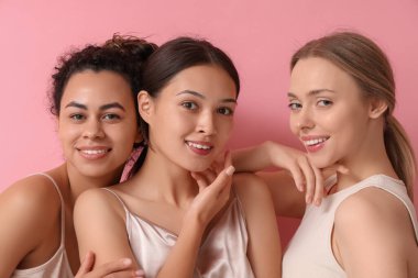 Pembe arka planda mutlu genç kadınlar