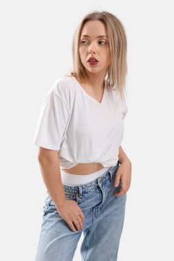 Hafif arka planda kotlu şık bir genç kadın.