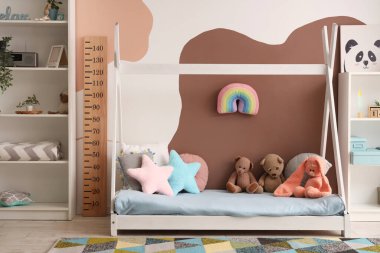 Şık çocuk odasının içi rahat yatak odası, oyuncaklar ve ahşap stadyumla dolu.