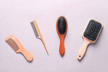 Gri arkaplanda saç fırçaları ve taraklar