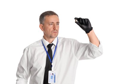 Beyaz arka planda mermisi olan olgun bir FBI ajanı.