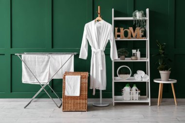 Çamaşır sepeti, kurutma makinesi ve raf ünitesi olan odanın içi.