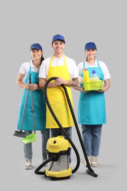 Temiz arka planda malzemeleri olan temizlik işçileri.