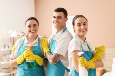 Yatak odasında deterjanı olan temizlik işçileri.