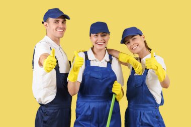 Temizlik işçileri sarı arkaplanda onay veriyorlar