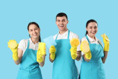 Mavi arka planda malzemeleri olan temizlik işçileri.