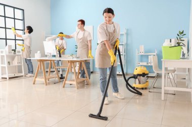 Bir grup genç hademe ofiste temizlik yapıyor.