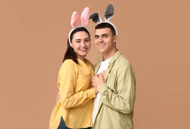 Bej arka planda Paskalya tavşanı kulaklı mutlu genç çift