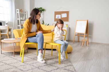 Ofiste ağlayan küçük bir kızla çalışan kadın psikolog.