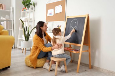 Ofisteki tahtaya psikolog çizen küçük kız.