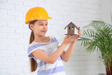 Odasında ev modeli olan küçük bir mimar