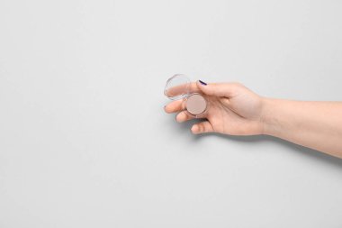 Gri arka planda göz farı olan kadın el.