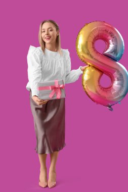 Elinde işitme cihazı olan genç bir kadın ve mor arka planda 8 şeklinde bir balon taşıyor. Uluslararası Kadınlar Günü